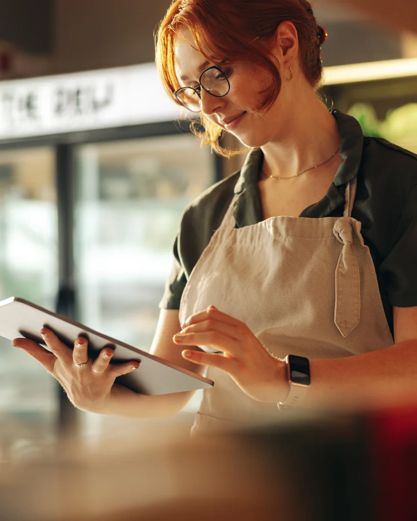 nimbus employee scheduling workforce management and compliance solution - female on tablet at workplace