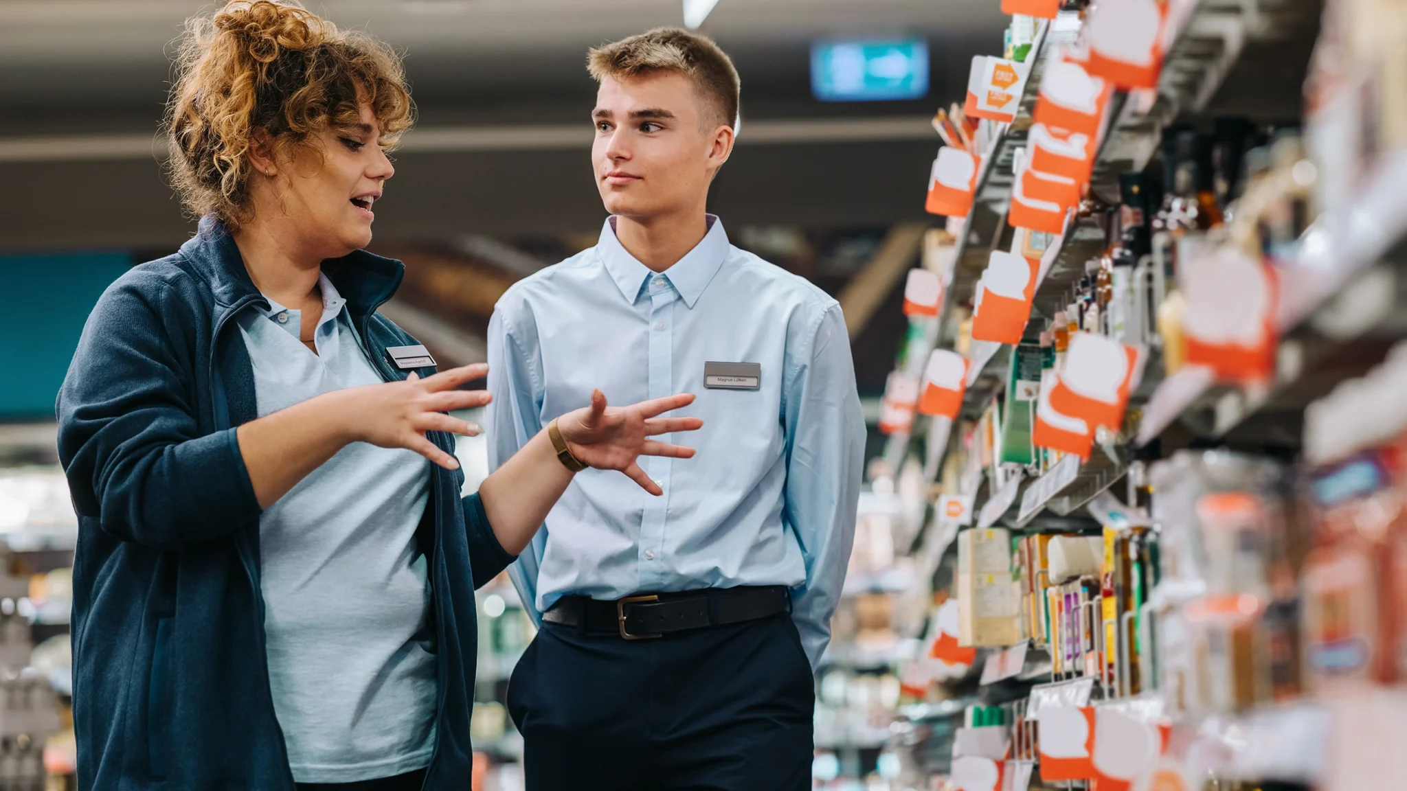 nimbus workforce management scheduling software - supermarket employees talking in aisle